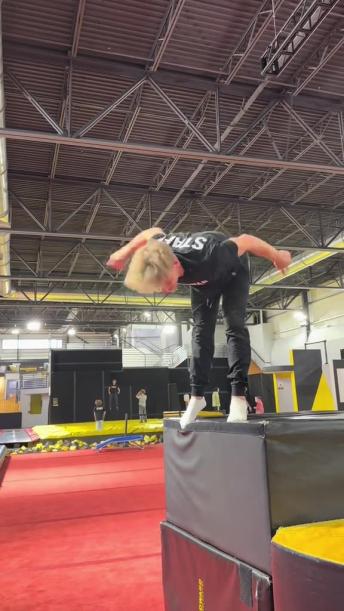 Parkour athlete impressively does a backflip jump on a high box 