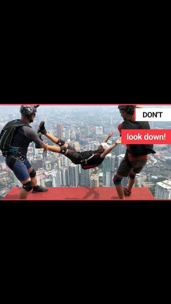 A crew of adrenaline junkies do freestyle stunt jumps off one of the tallest towers in Malaysia.