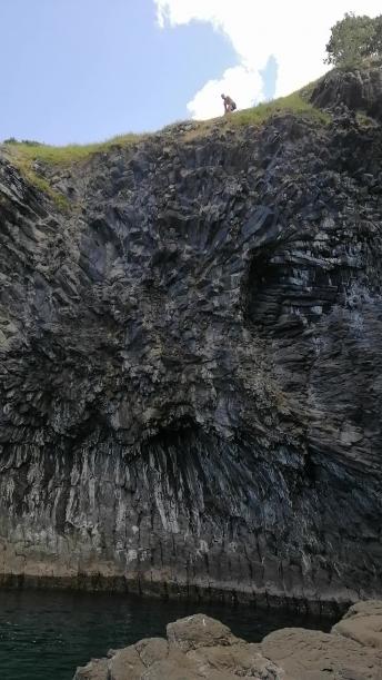 Man jumps off black asphalt cliff